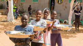 Enfants portant des plats devant une école, Dakar © grdr