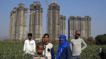 Famille d'agriculteurs avec bâtiments en arrière-plan, Inde ©Mathieu Roy