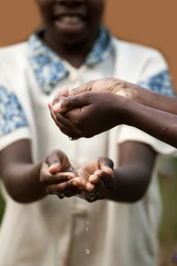 Image de deux personnes se donnant de l'eau dans les mains